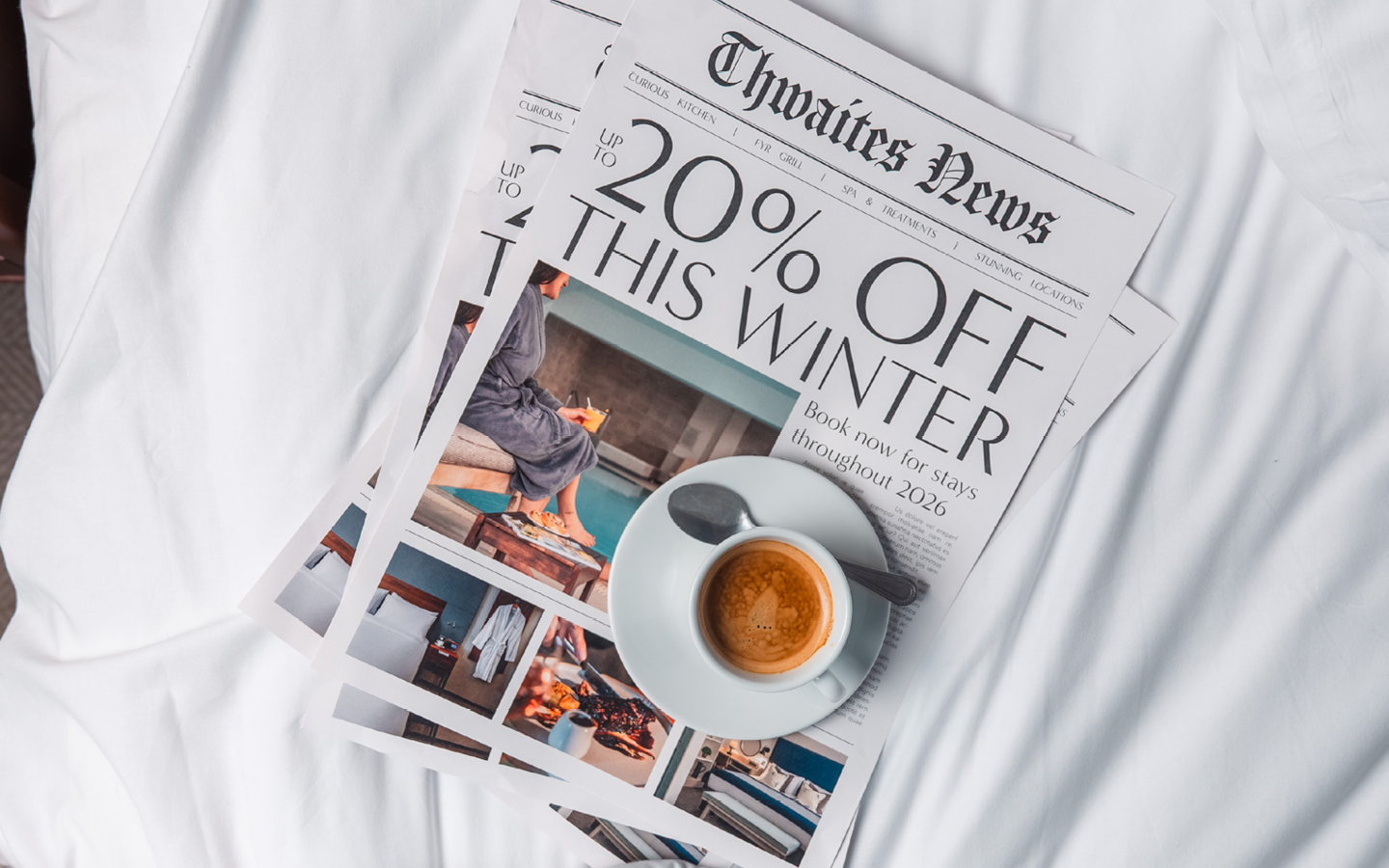 Magazine and coffee on hotel bed with the headline "Up to 20% off this winter"